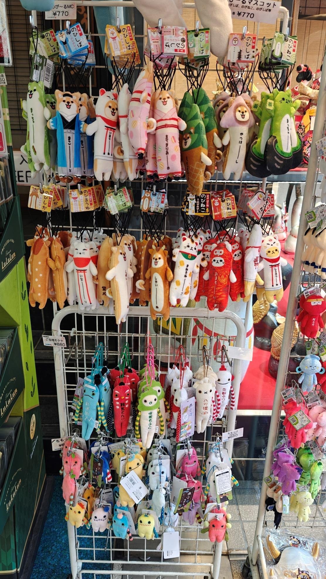 Colorful plush toys displayed on a rack in a store