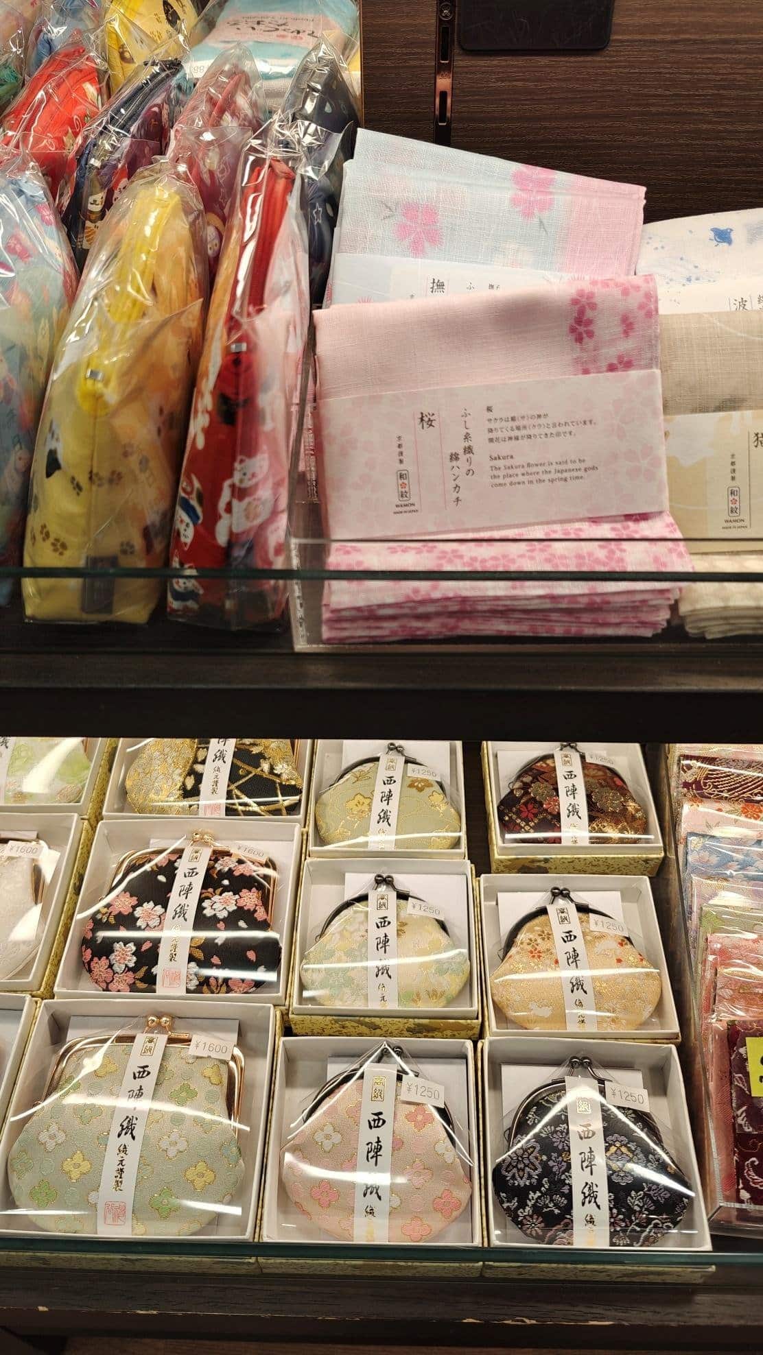 Colorful pouches and handkerchiefs with floral designs displayed.