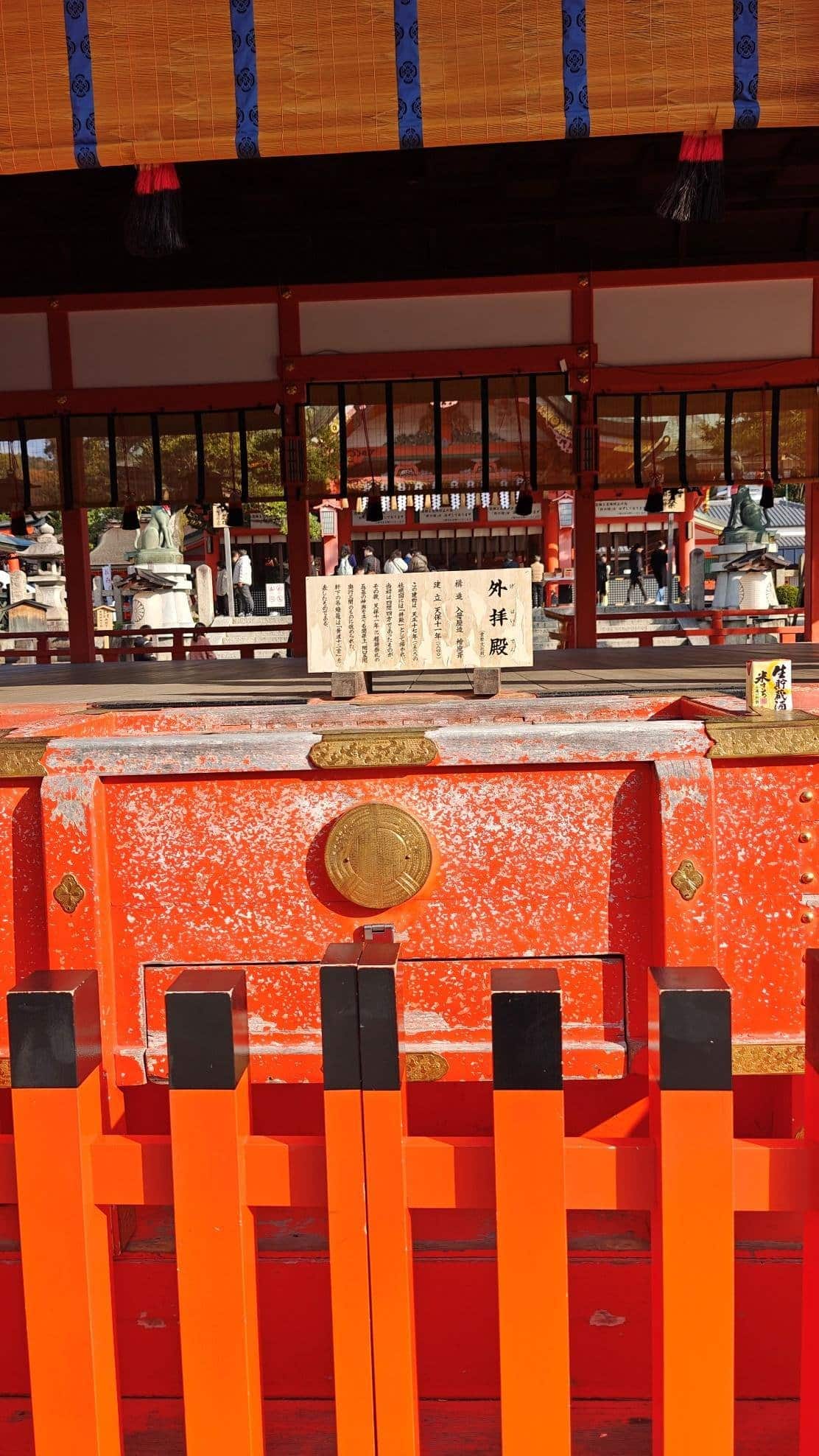 Colorful shrine with orange and gold details, wooden signage