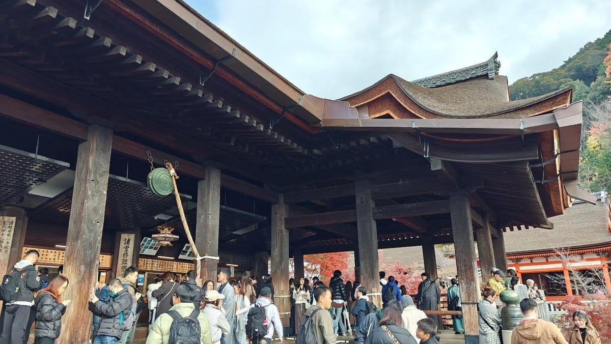Crowd gathered at traditional Japanese temple with ornate roof