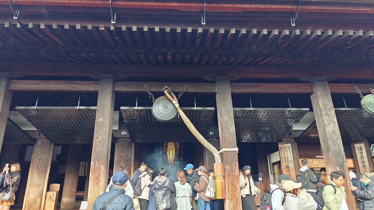 Crowd outside a traditional wooden temple entrance