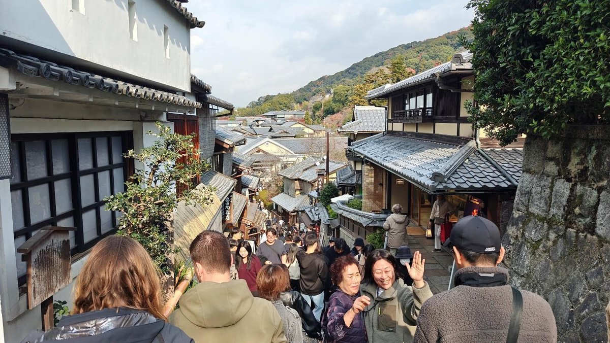 Crowded street in traditional Japanese village with tiled roofs