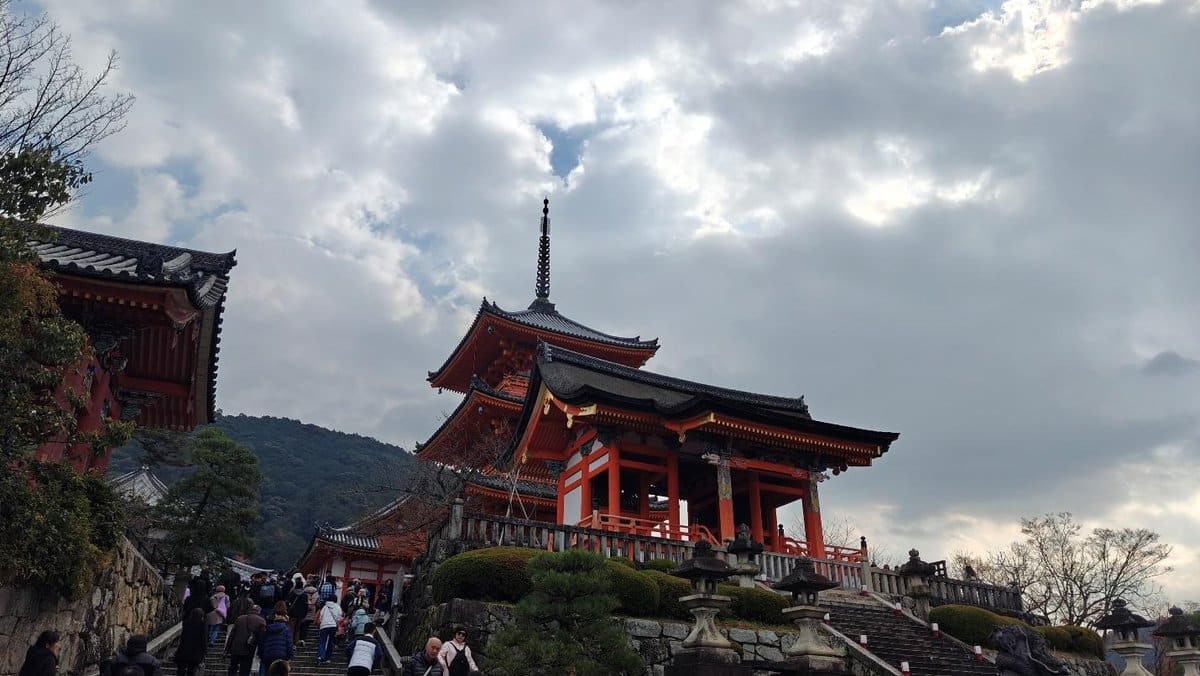 Crowded temple steps under cloudy sky, traditional architecture