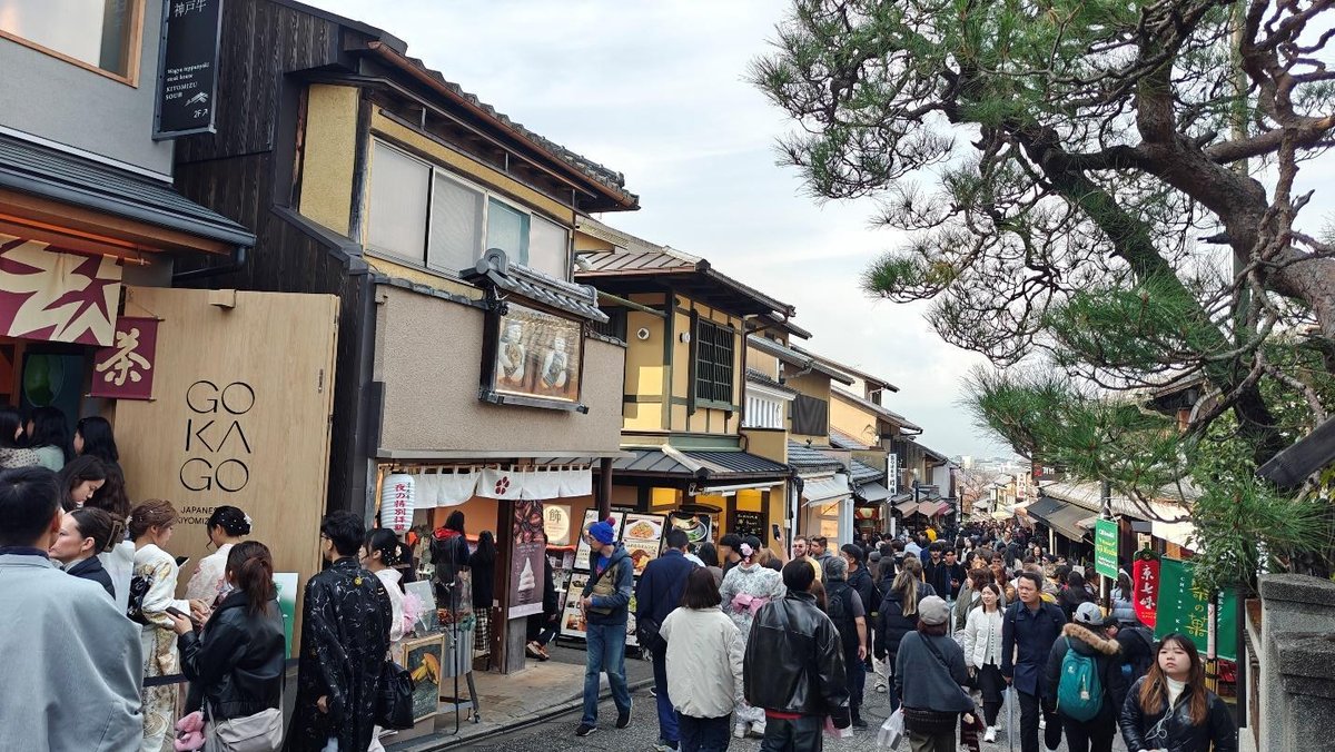 Crowded traditional street with shops and tourists in vibrant attire