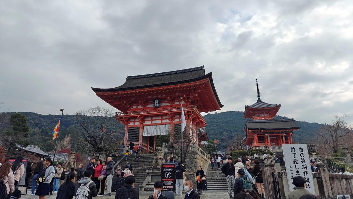 Crowds at Kyoto temple under cloudy skies