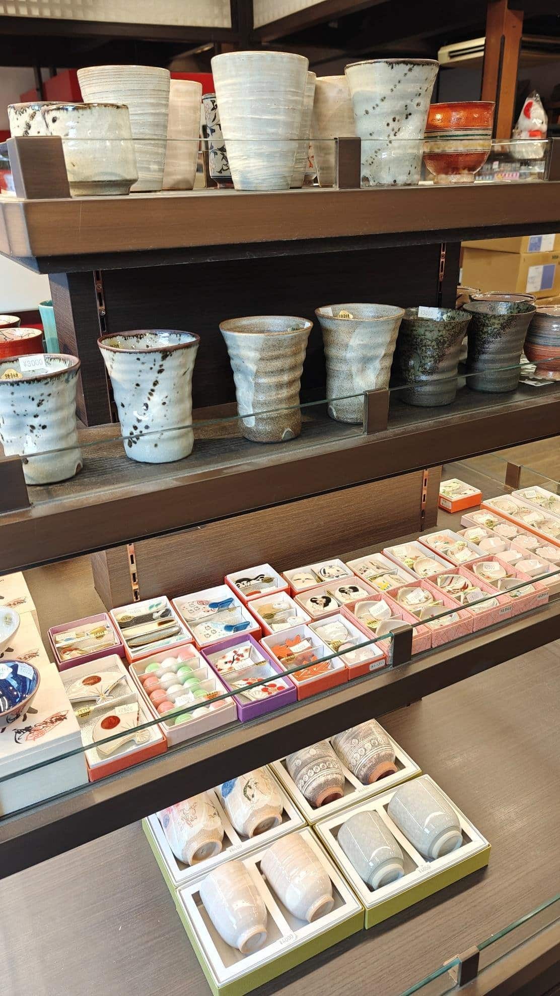 Display of ceramic cups and colorful trinkets in a shop