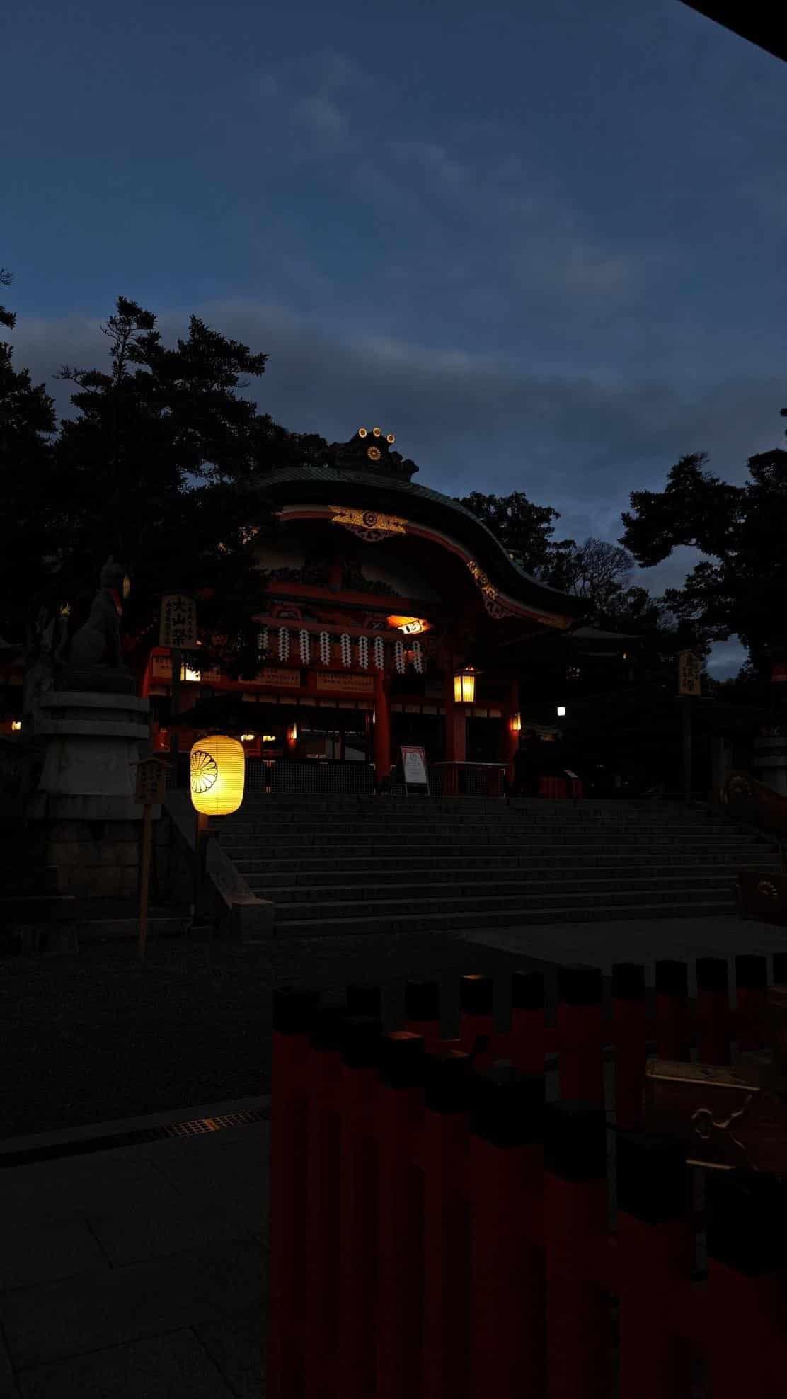 Illuminated traditional shrine at dusk with lanterns