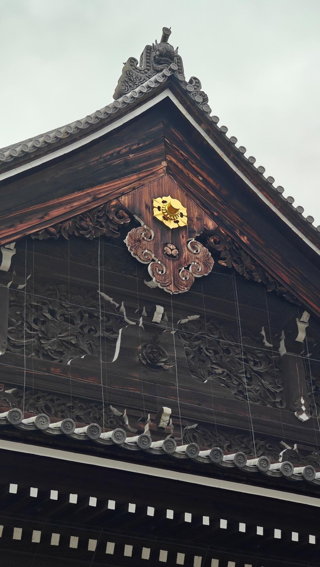 Intricate wooden pagoda roof with ornate carvings and gold accent