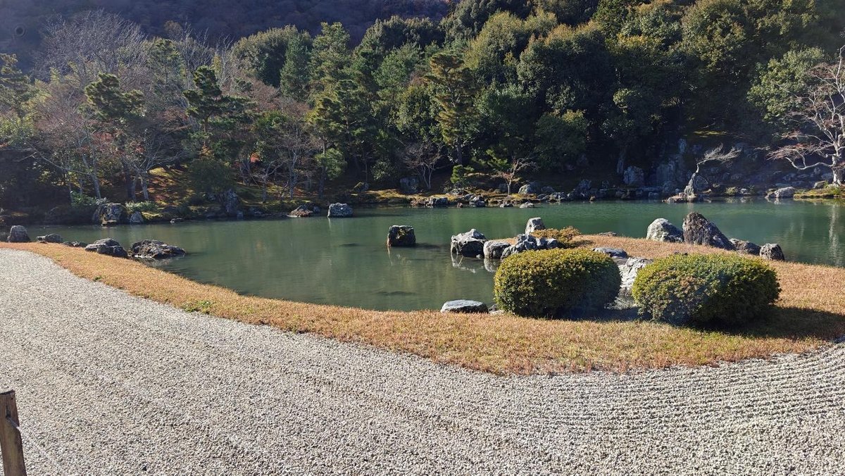 Japanese garden with pond, rocks, trees, and manicured sand