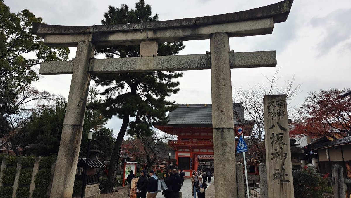 Japanese torii gate with people near shrine entrance