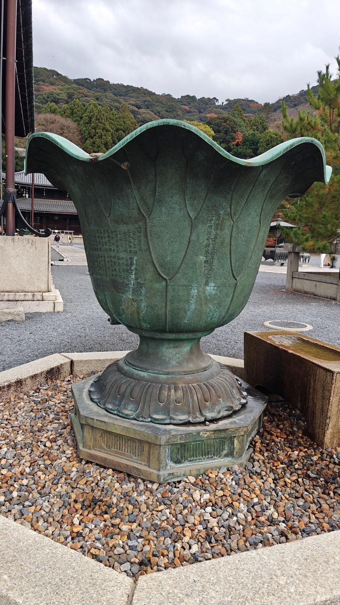 Large bronze urn with engraved pattern in a stone courtyard