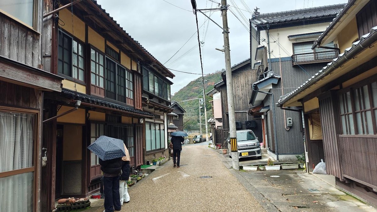 Narrow street with umbrellas and traditional wooden houses