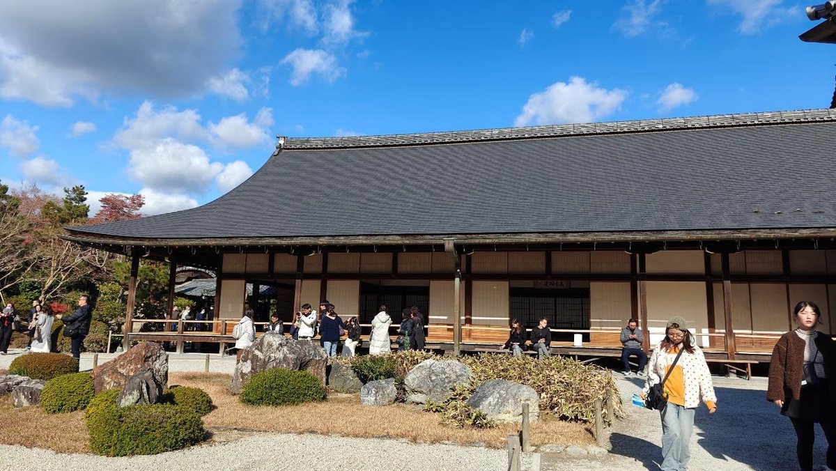People exploring traditional Japanese building under blue sky
