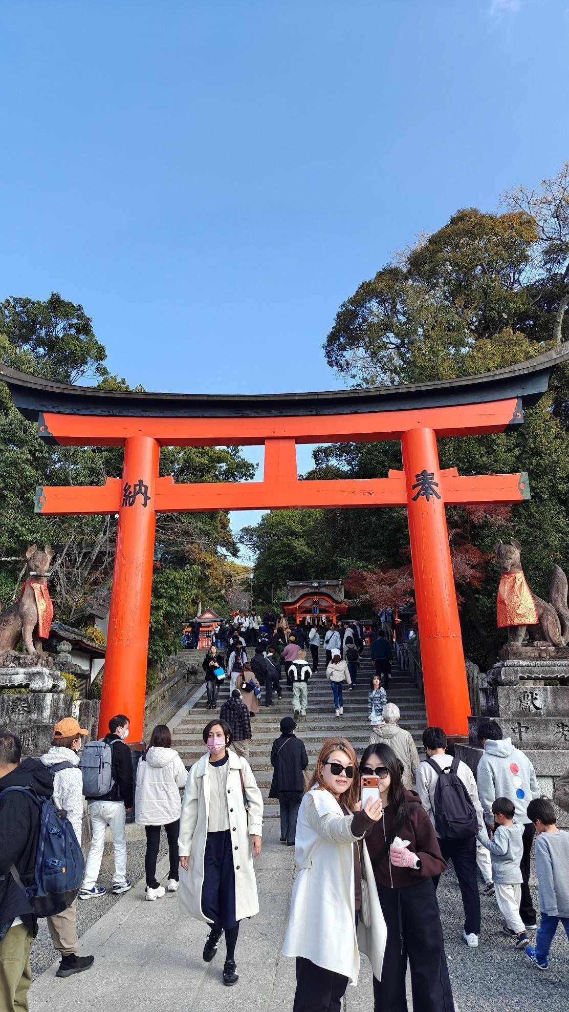 People under red torii gate at Fushimi Inari Shrine