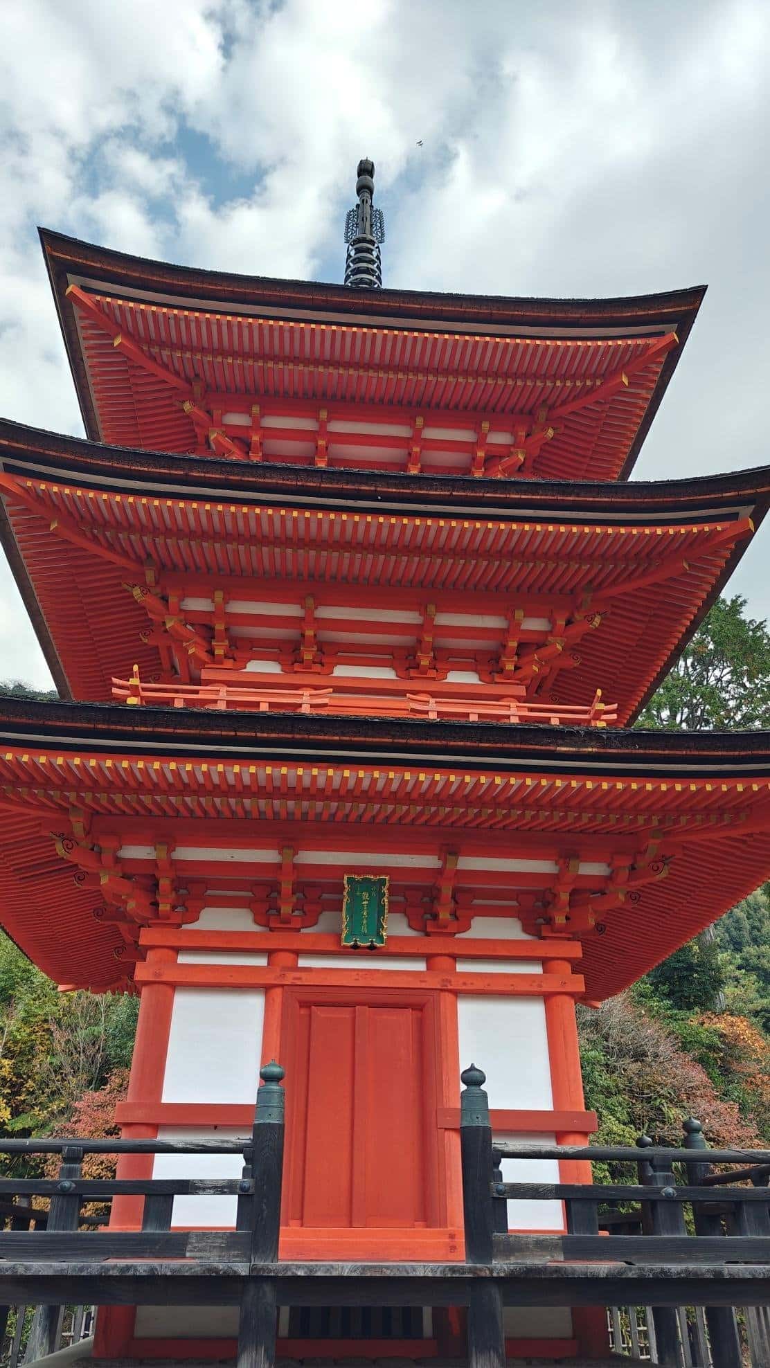 Red and white wooden pagoda with lush greenery background