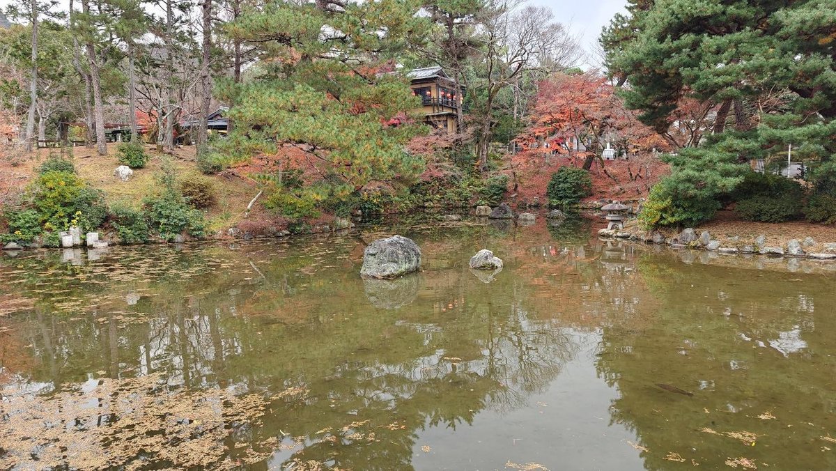 Serene pond with autumn trees and traditional architecture