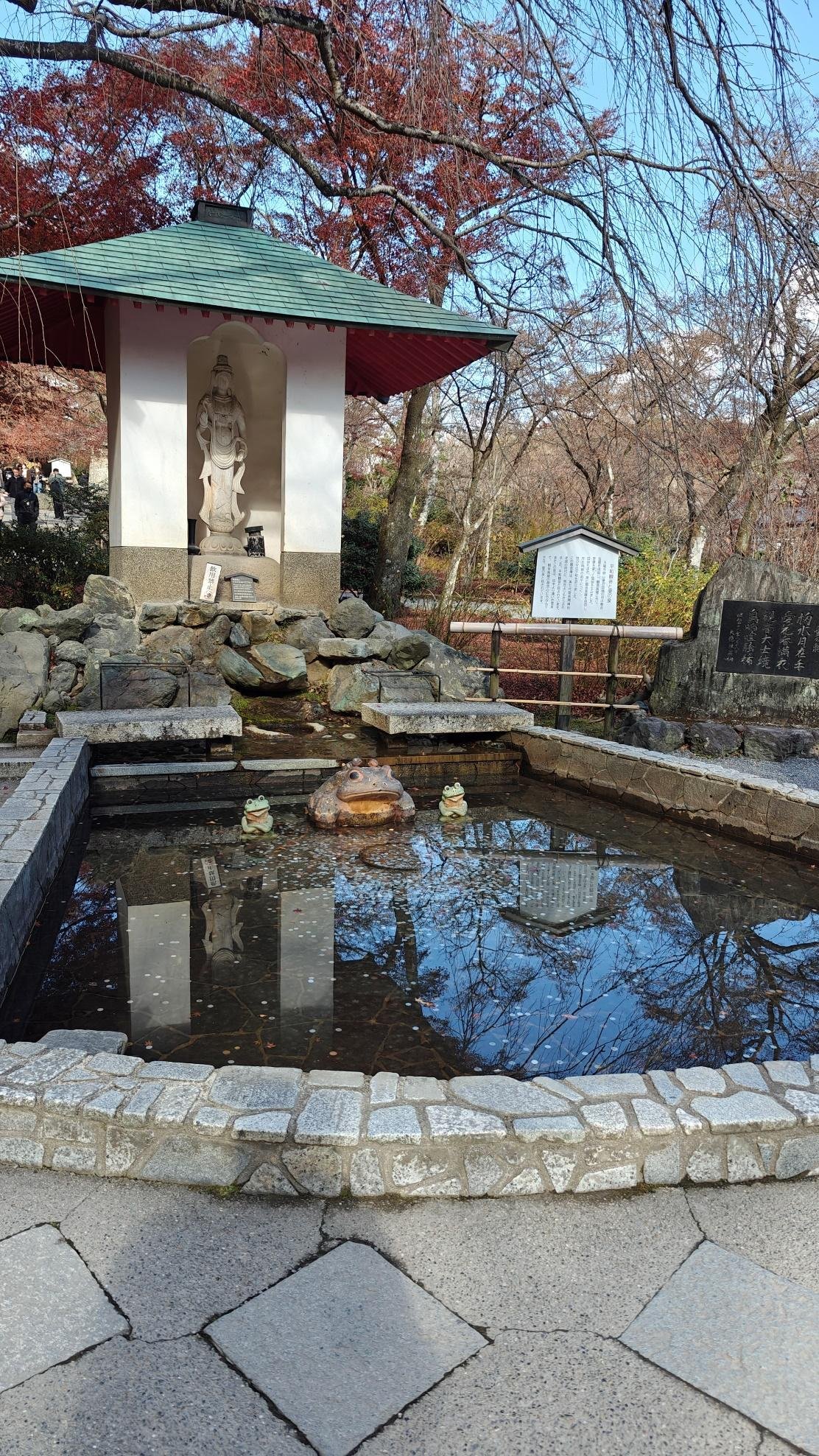 Serene pond with statue and autumn trees in tranquil garden