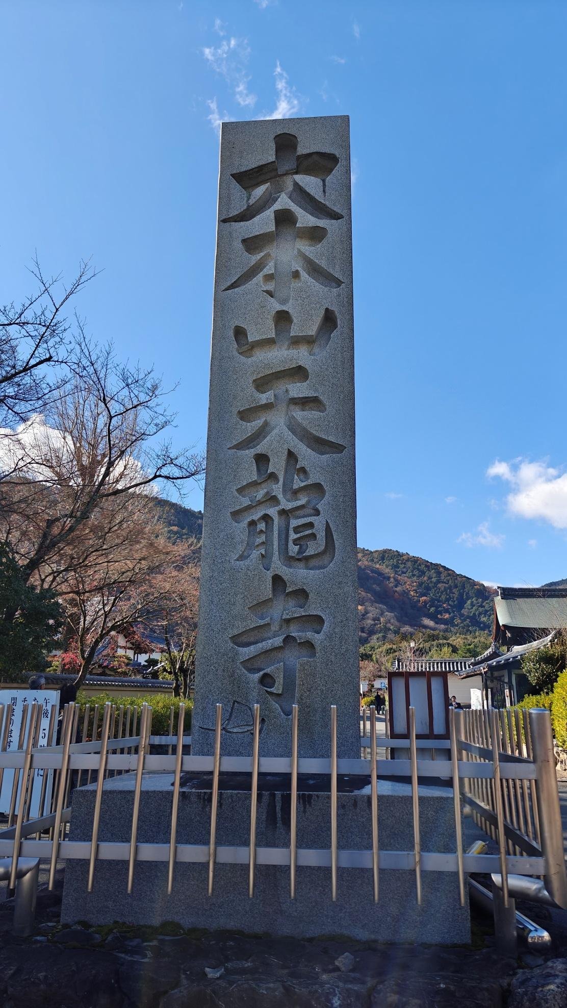 Stone monument with Japanese kanji under blue sky