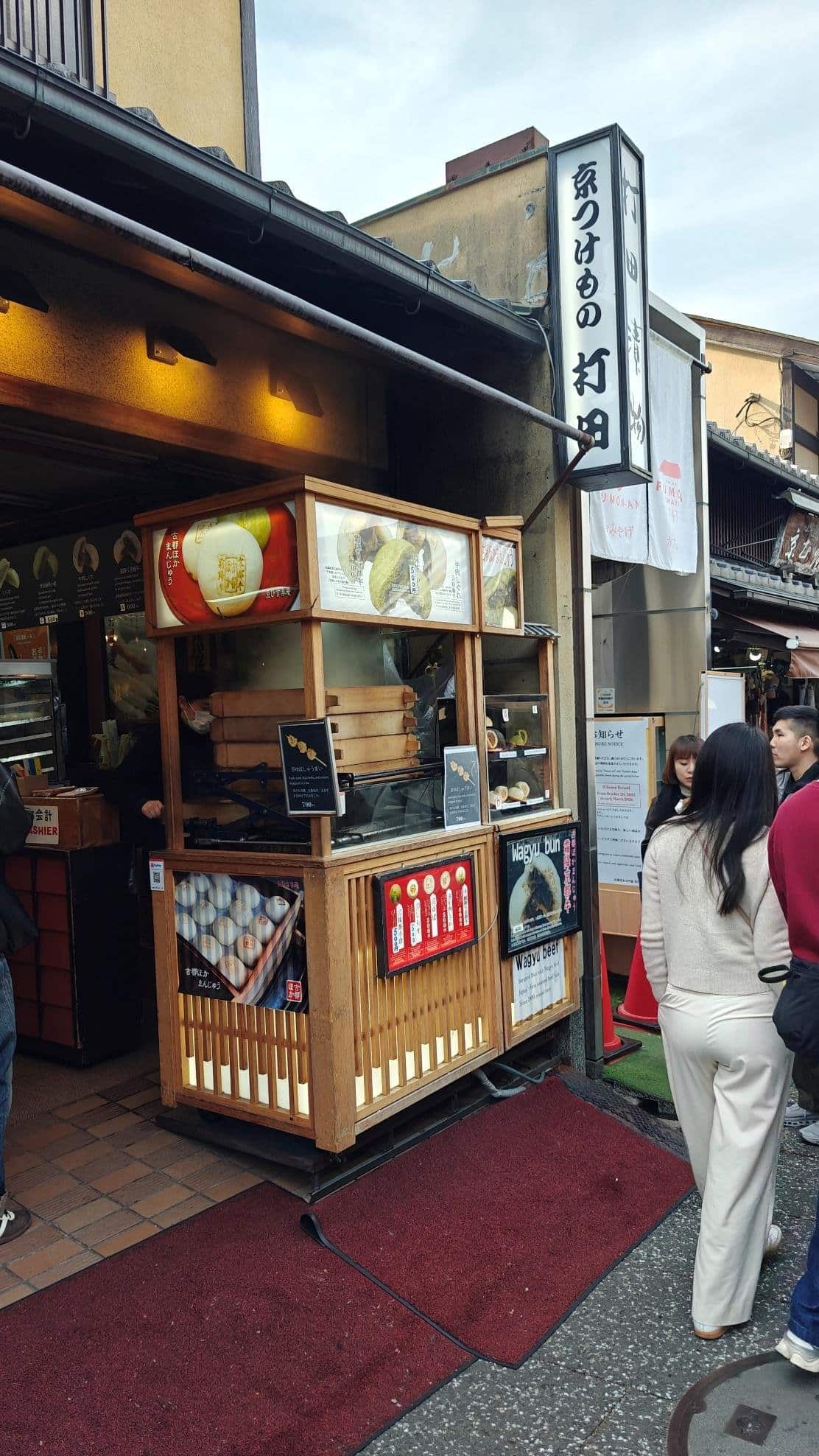 Street food stall with people outside in urban setting