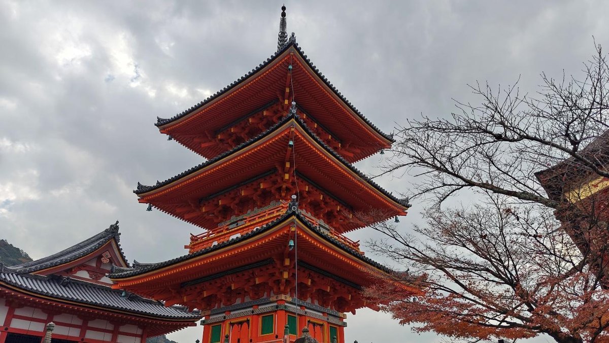 Three-story pagoda under cloudy sky with bare trees