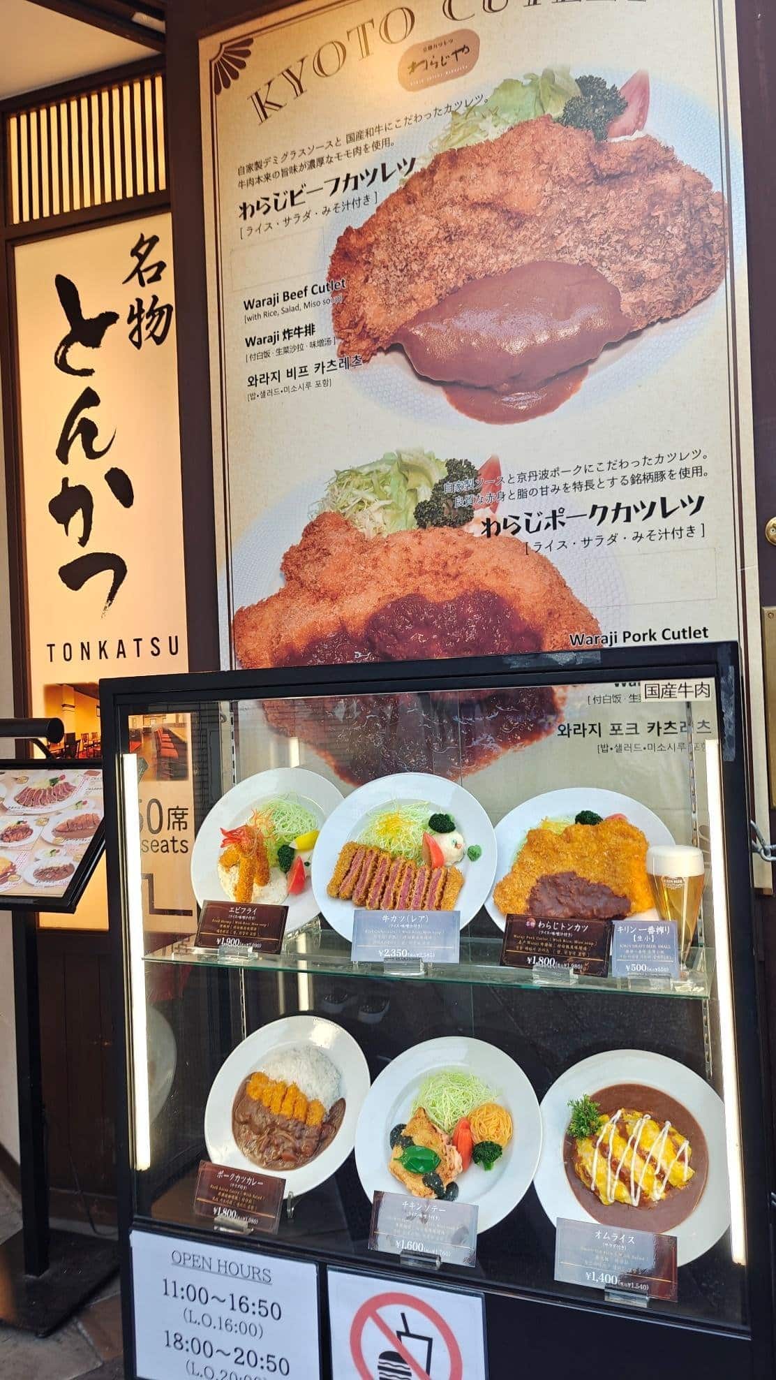 Tonkatsu restaurant display with plated cutlets and open hours