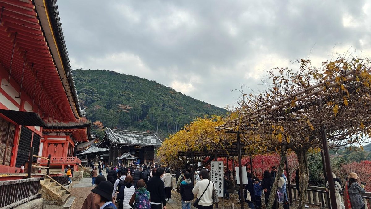 Tourists at shrine with autumn foliage and distant mountains