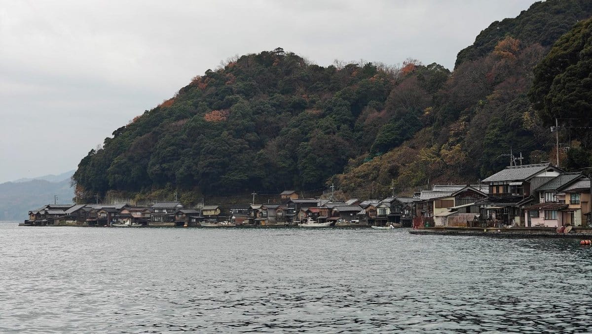 Traditional houses by the coast under cloudy sky