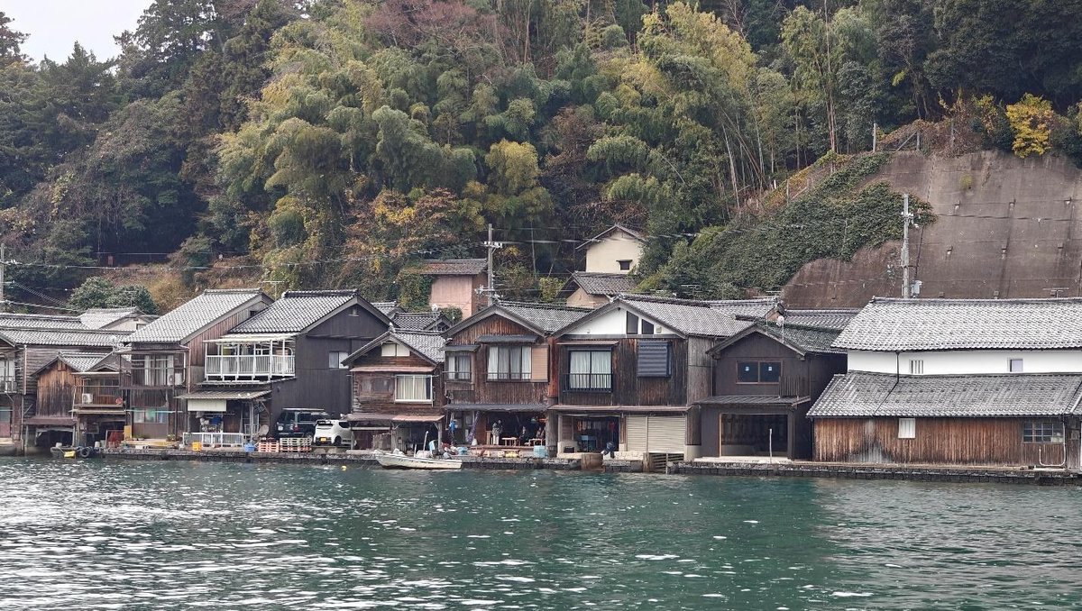Traditional Japanese boathouses along a serene waterfront.