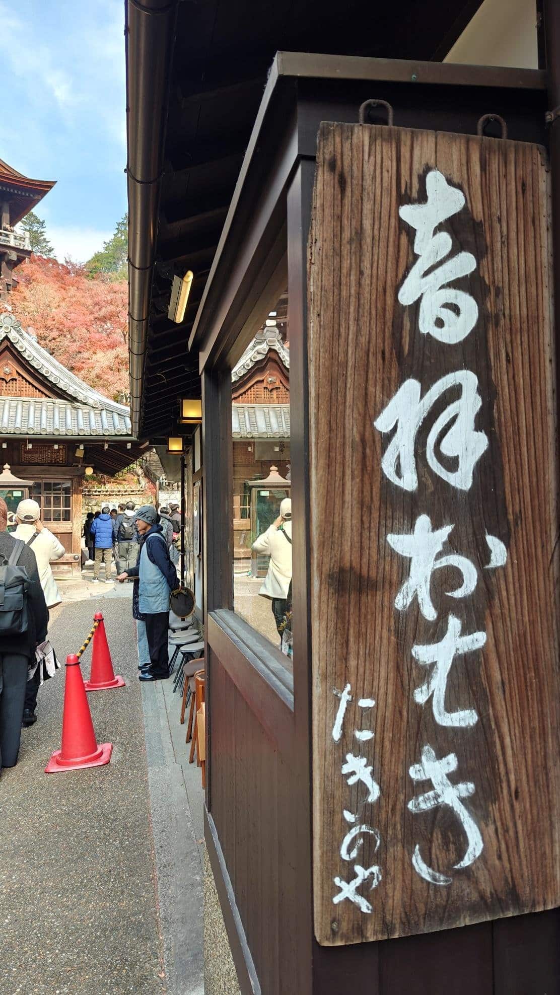 Traditional Japanese building with wooden sign and visitors