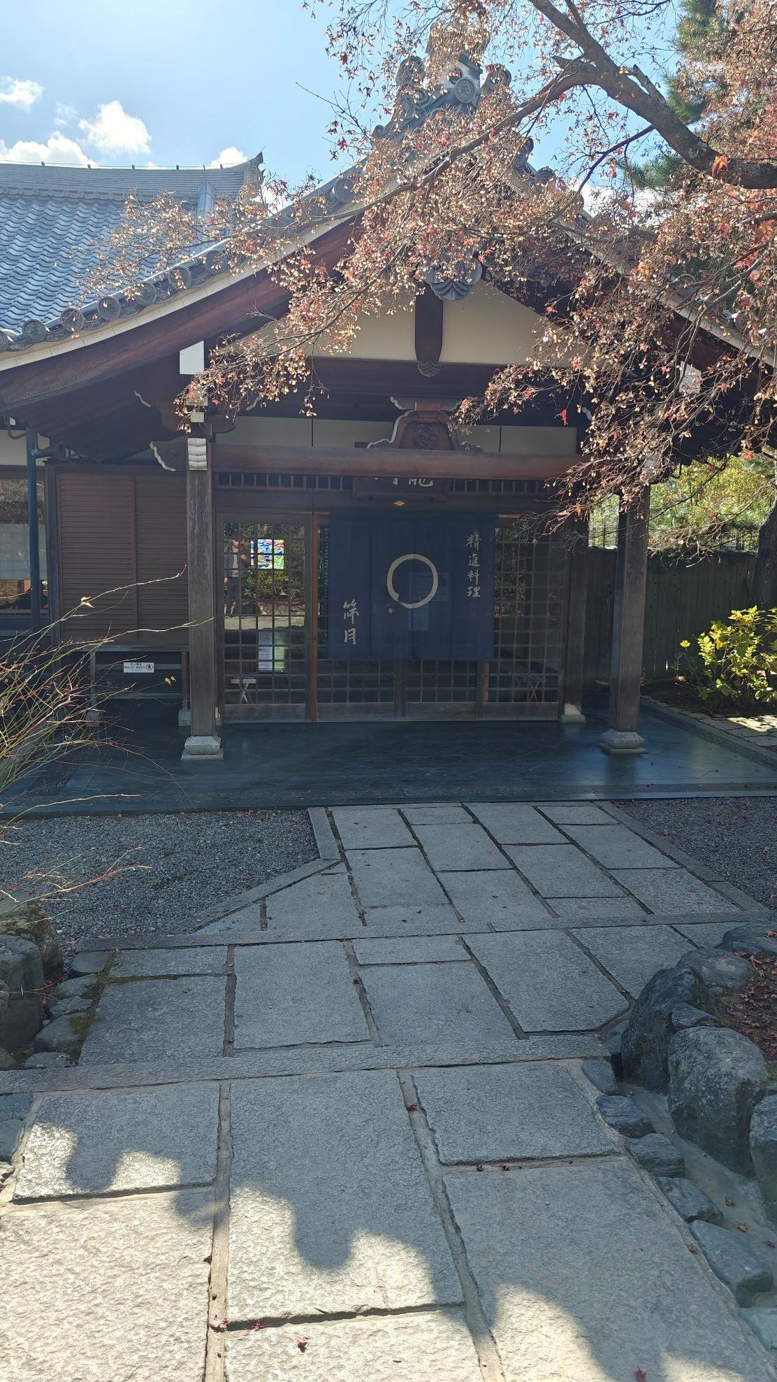 Traditional Japanese entrance with sliding doors and foliage
