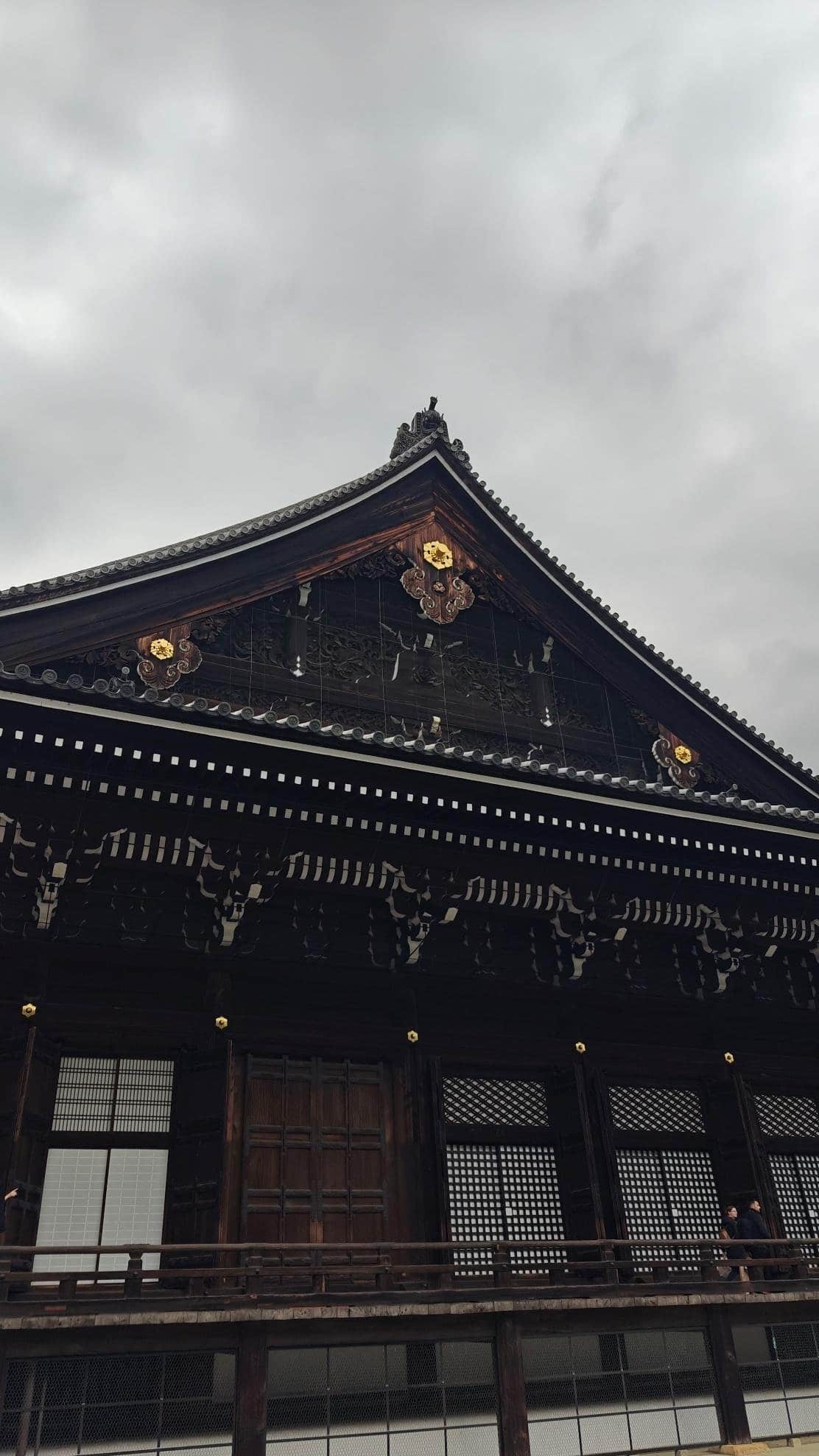 Traditional Japanese temple roof under cloudy sky