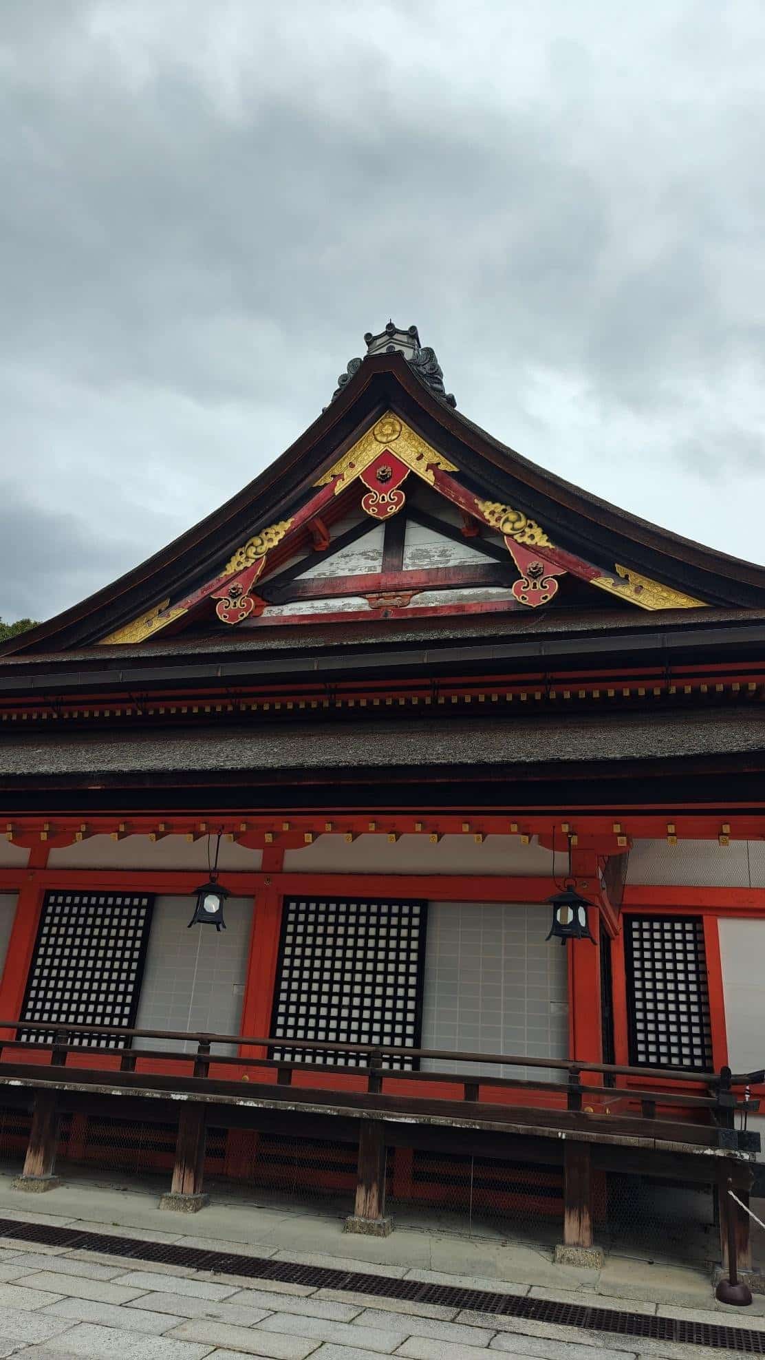 Traditional Japanese temple with ornate wooden roof, cloudy sky