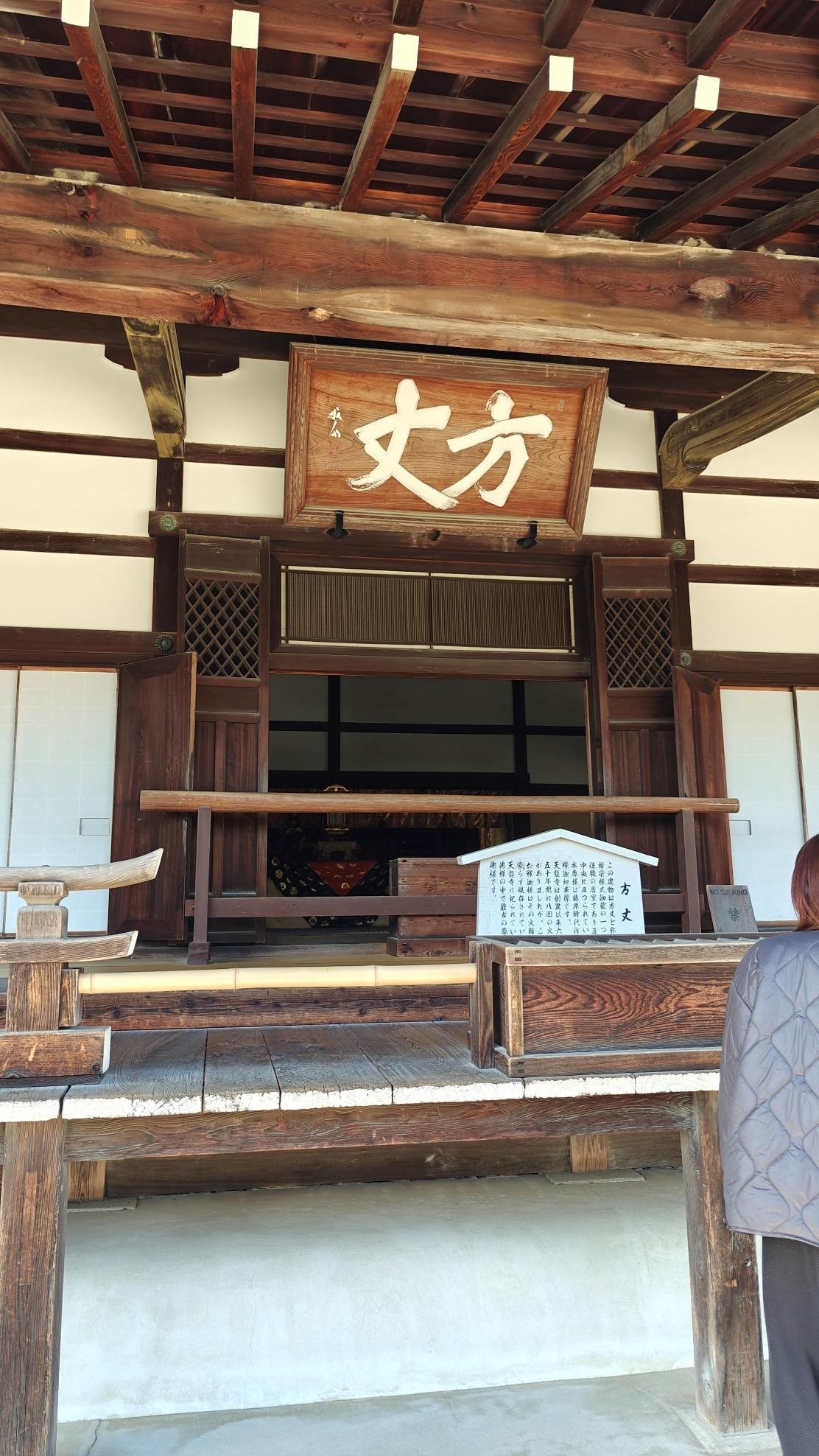 Traditional Japanese wooden temple entrance with kanji sign