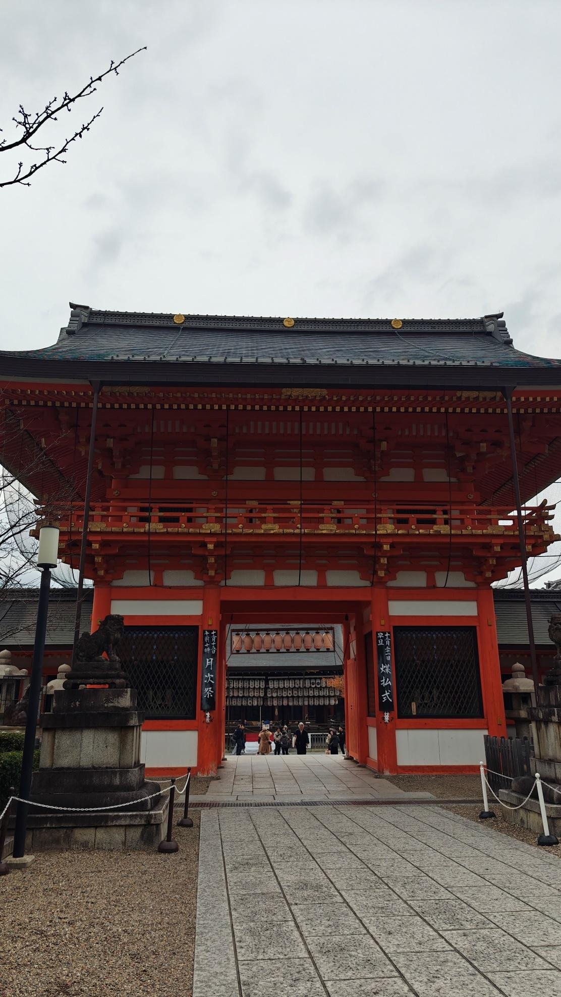 Traditional red temple gate under cloudy sky