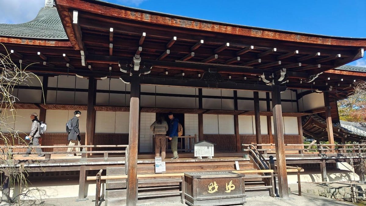 Traditional wooden building with people walking past