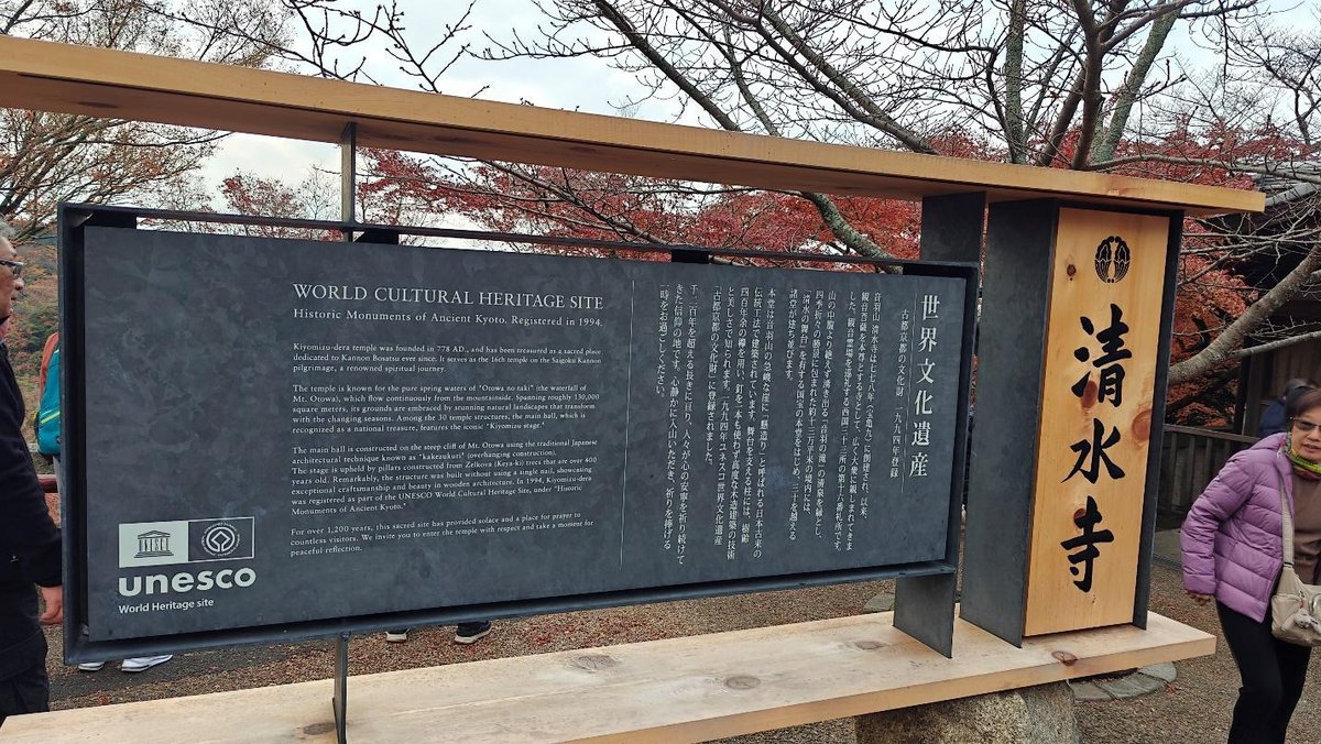 UNESCO World Heritage sign with autumn foliage and visitors
