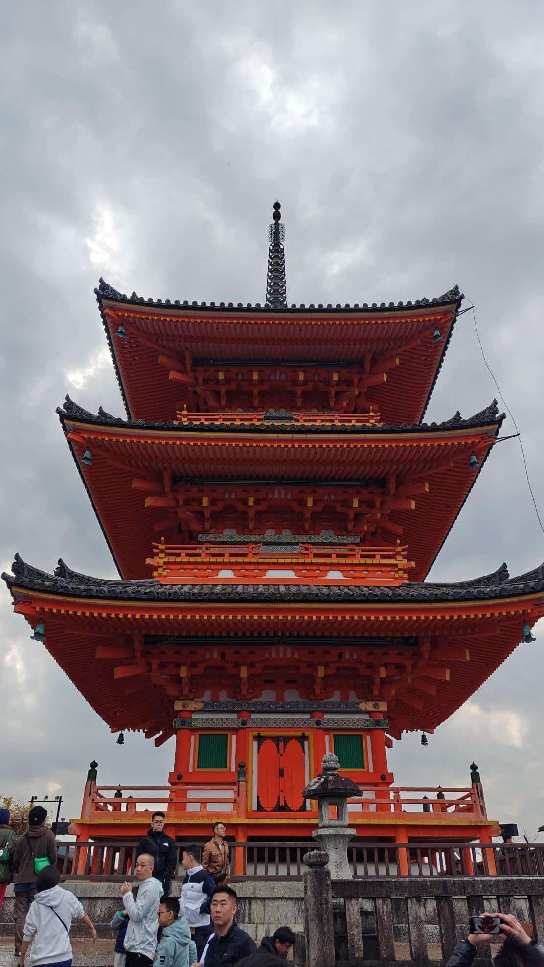 Vibrant Japanese pagoda under cloudy skies with visitors below