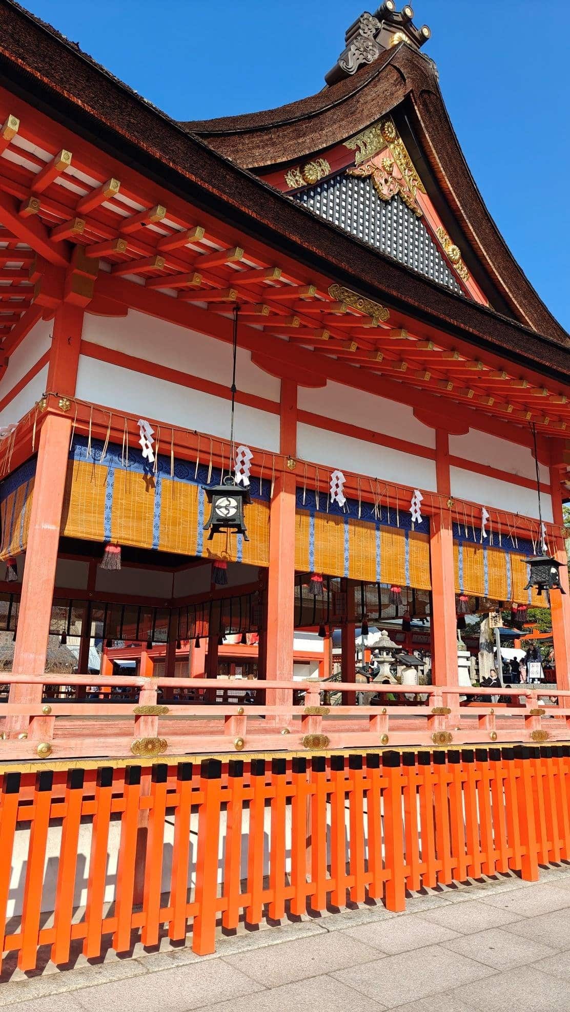Vibrant red and orange Japanese temple under clear blue sky