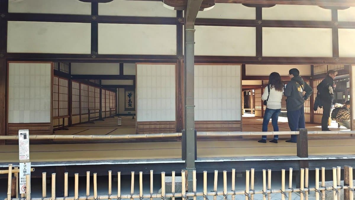 Visitors at a traditional Japanese temple interior