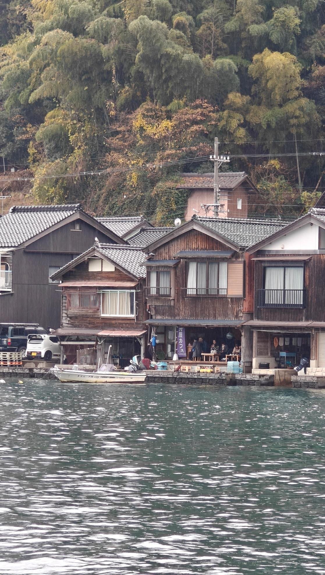 Wooden houses by a scenic lakeside with lush greenery
