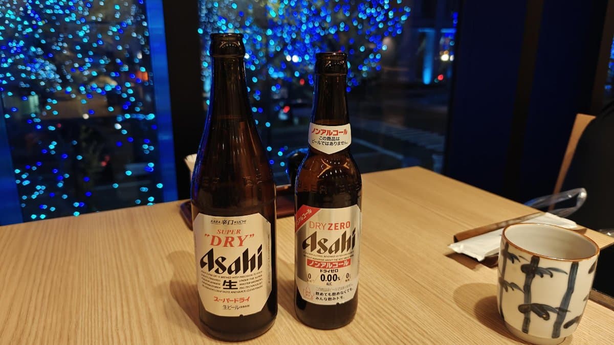 Asahi beers on table, blue lights backdrop