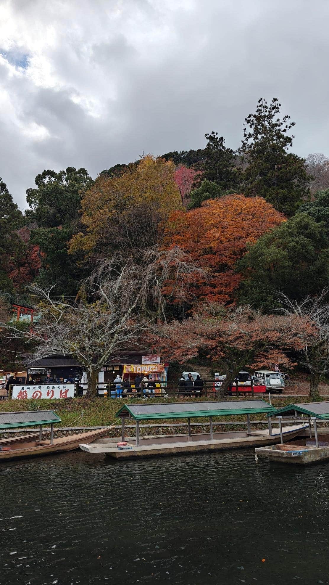 Autumn trees by river with food stalls and boats