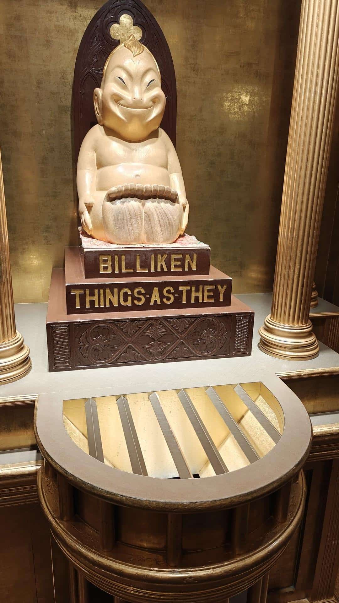Billiken statue with gold backdrop