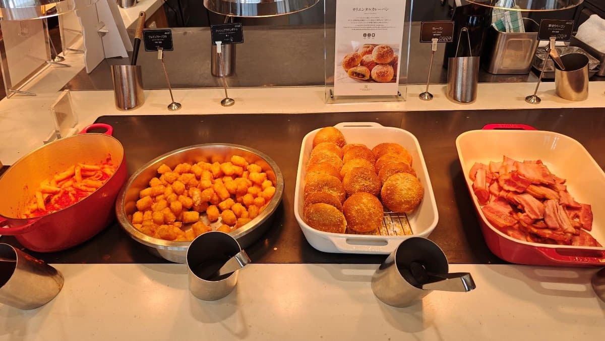 Buffet with pasta, croquettes, buns, bacon