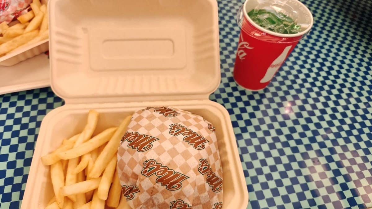 Burger, fries, and drink on checkered table