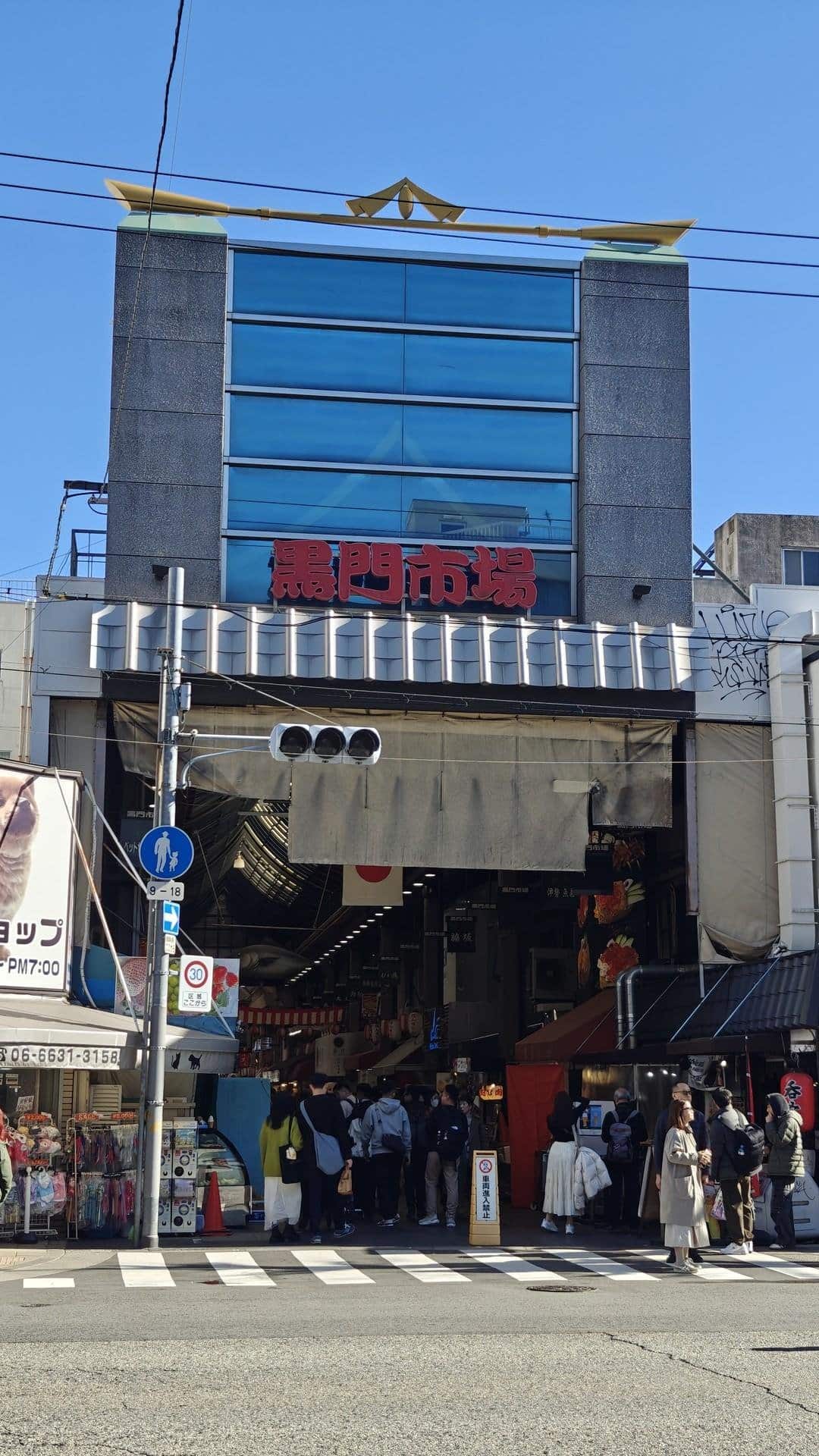 Bustling market entrance under blue sky