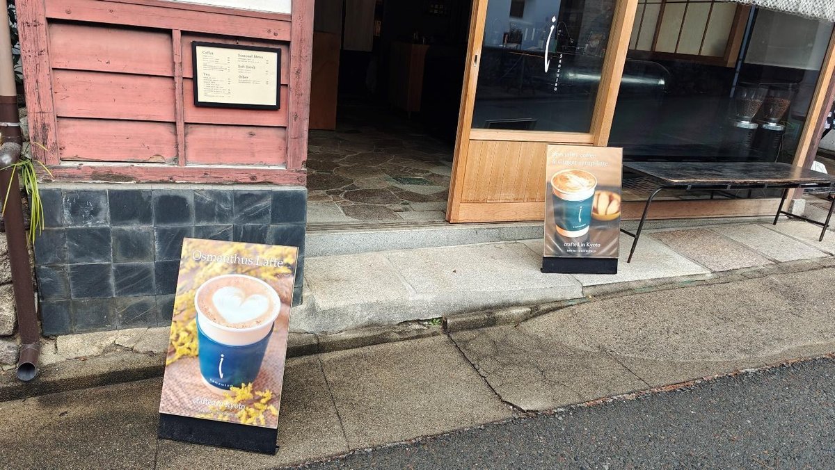 Cafe entrance with latte posters on rustic pavement