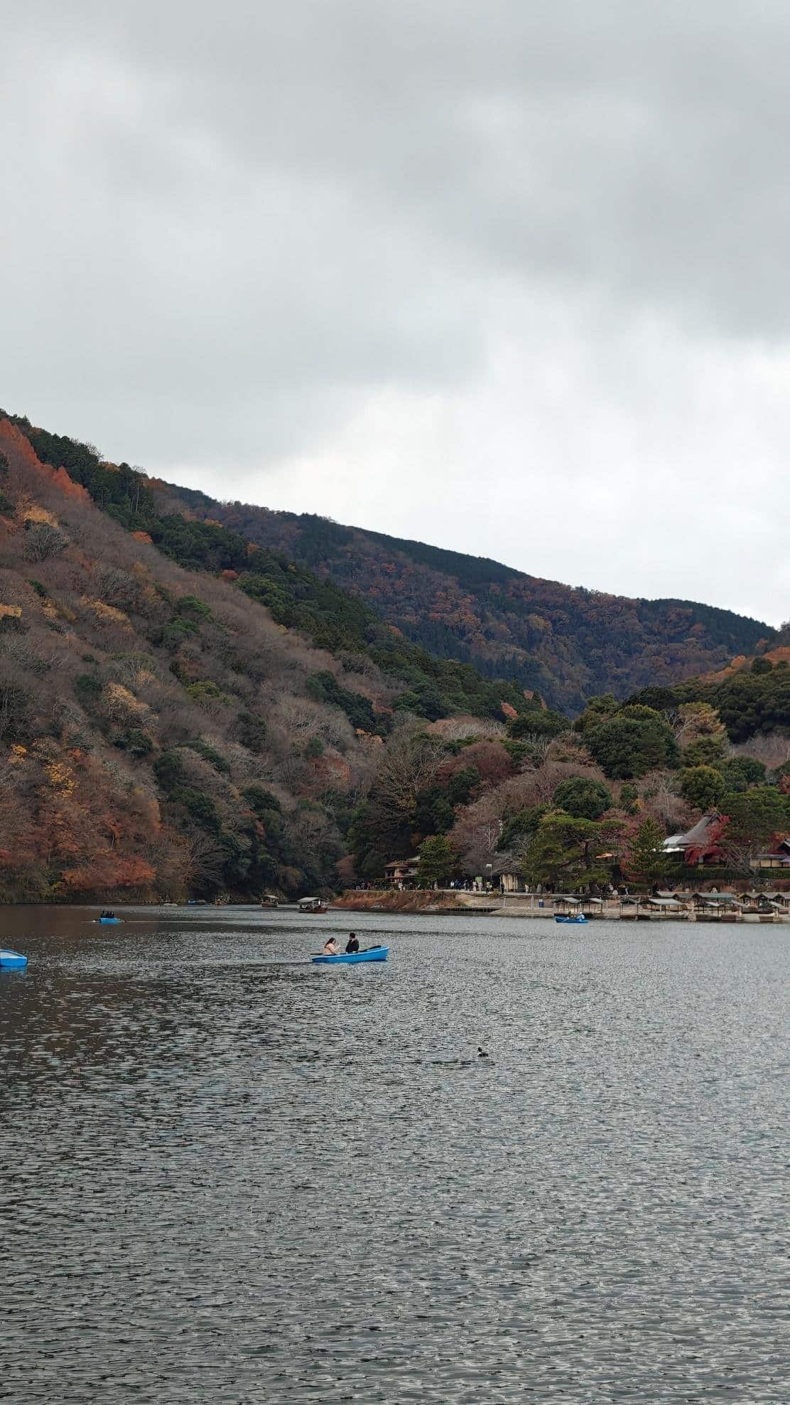 Calm lake with rowboats and autumn-colored hills