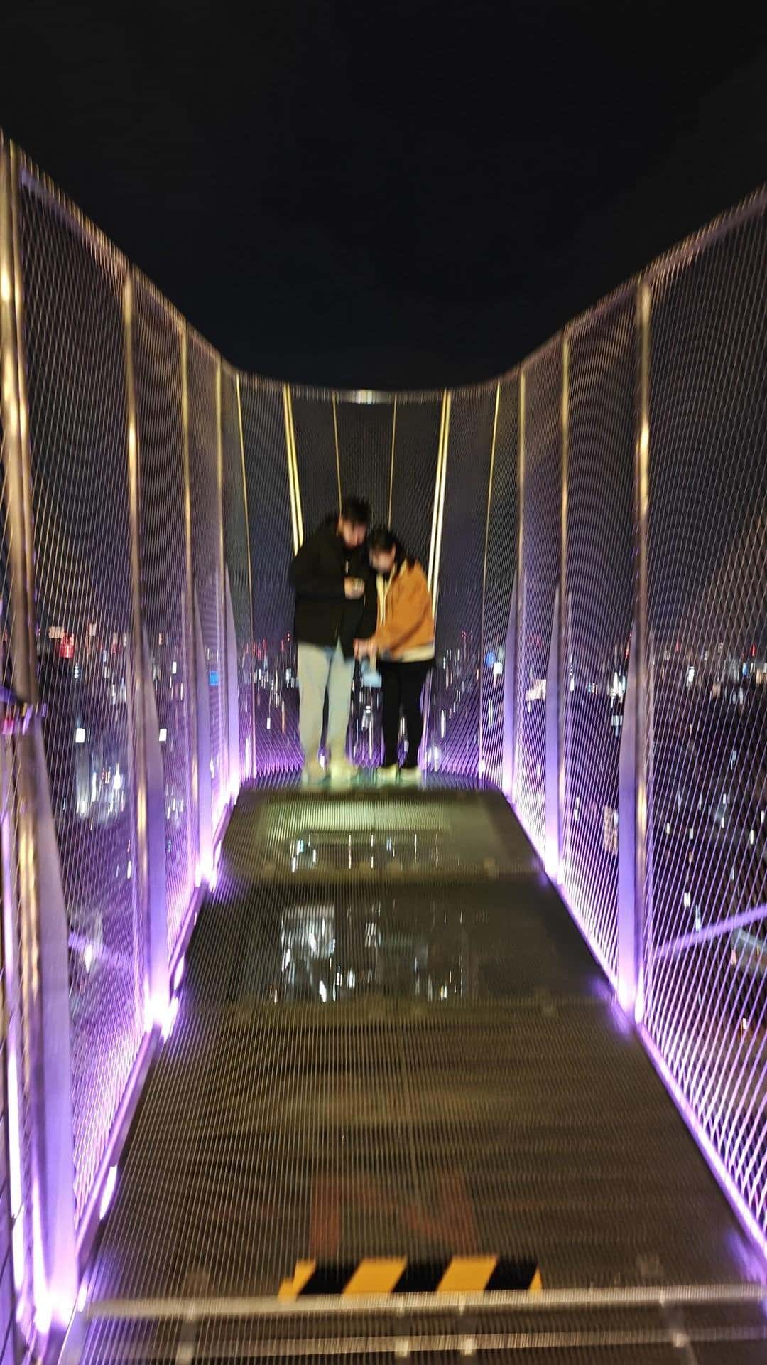 Couple on illuminated bridge at night