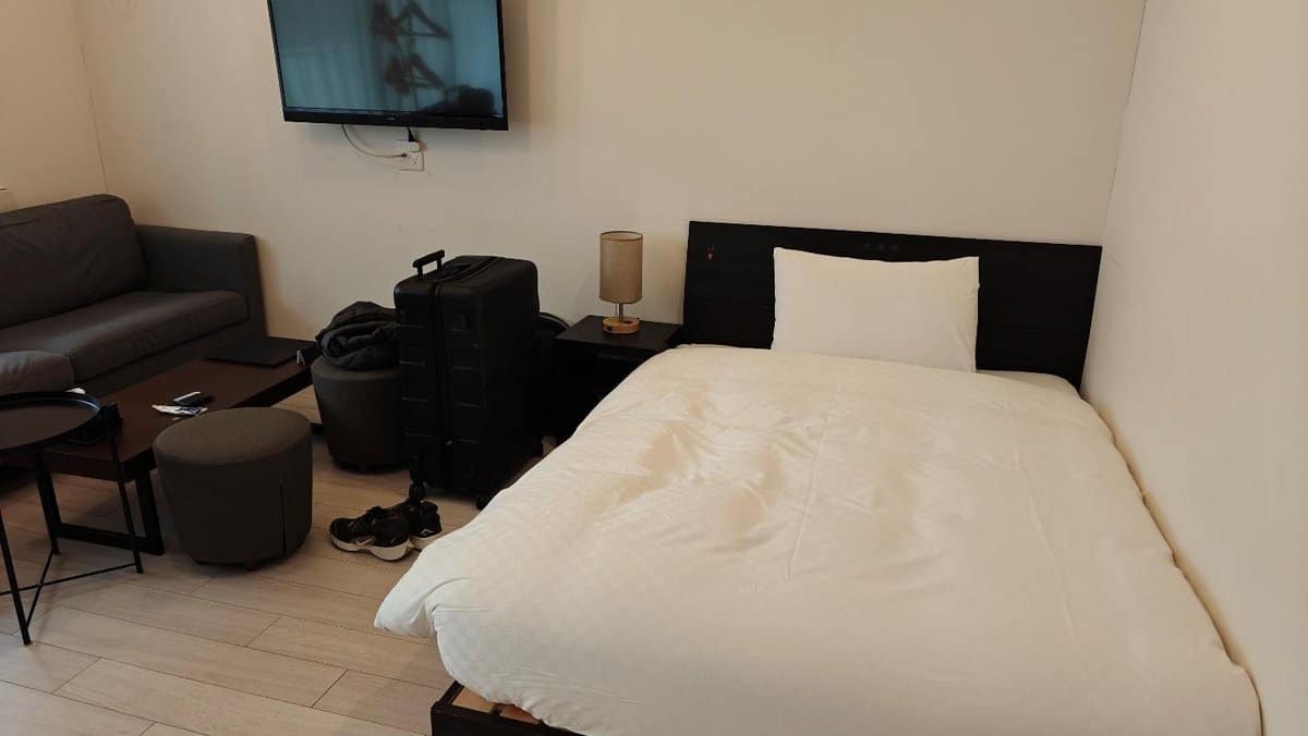 Cozy bedroom with luggage and sofa